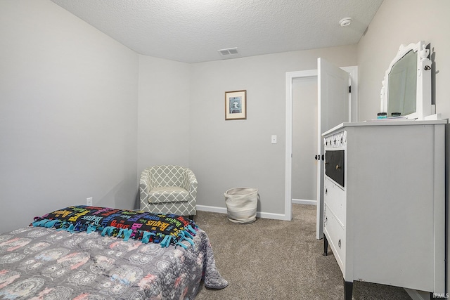 bedroom with carpet floors, baseboards, a textured ceiling, and visible vents