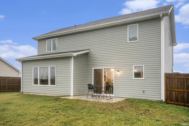 back of house featuring fence, a patio, and a lawn