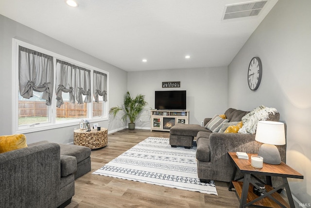 living room featuring visible vents, recessed lighting, baseboards, and wood finished floors