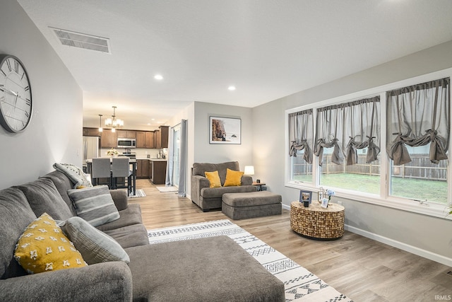living area featuring recessed lighting, visible vents, an inviting chandelier, and light wood-style floors