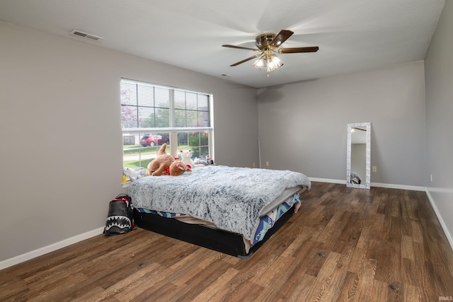 bedroom with baseboards, wood finished floors, and visible vents