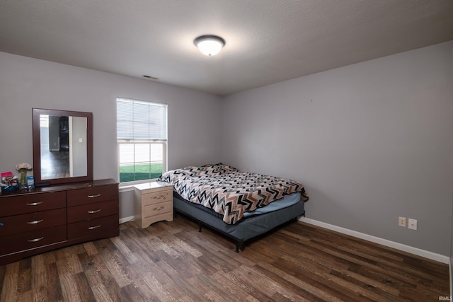 bedroom featuring dark wood-type flooring, baseboards, and visible vents