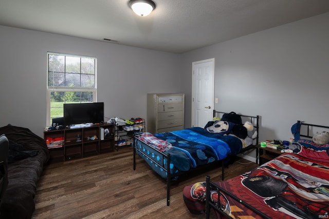 bedroom featuring wood finished floors and visible vents