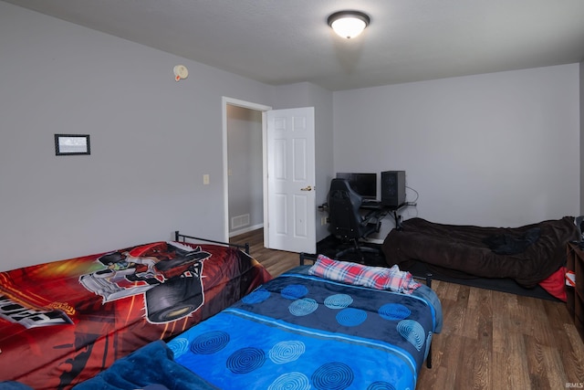 bedroom featuring visible vents and wood finished floors
