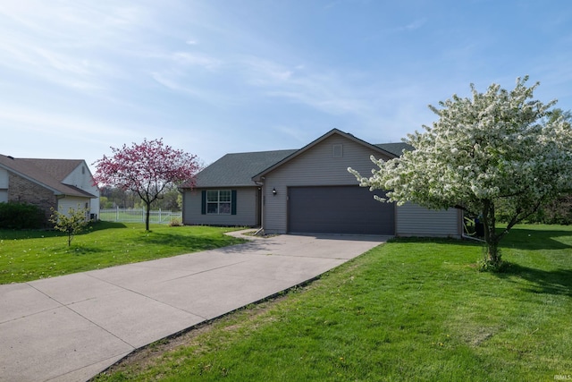 ranch-style home with concrete driveway, an attached garage, fence, and a front yard