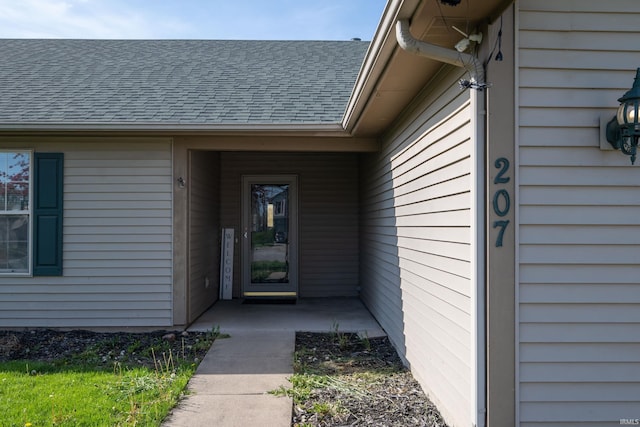 property entrance featuring a shingled roof