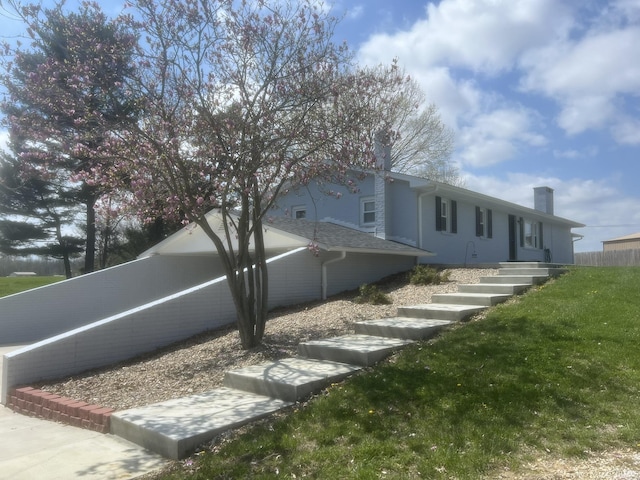 view of property exterior featuring a lawn and a chimney