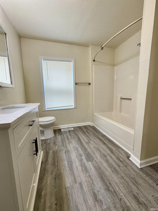 full bath with vanity, toilet, wood finished floors, and visible vents