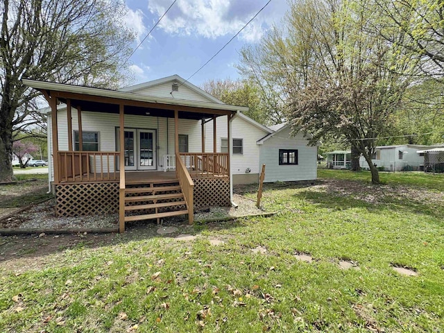 back of house featuring a yard and covered porch