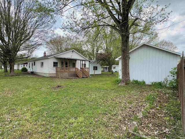 back of house featuring a yard and covered porch