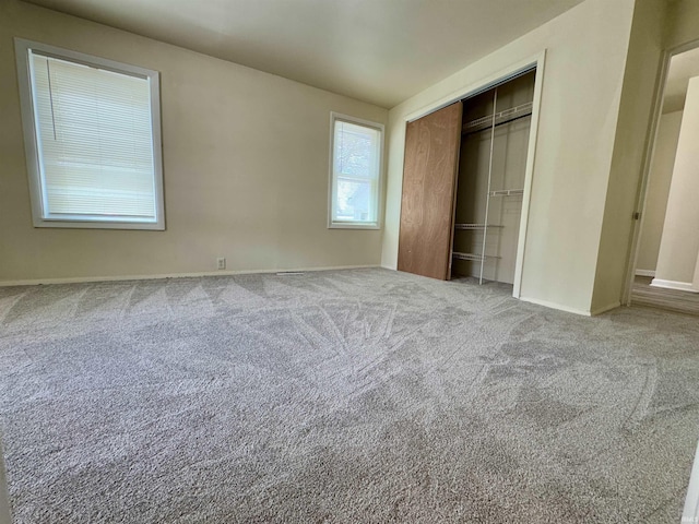 unfurnished bedroom with carpet flooring, baseboards, and a closet