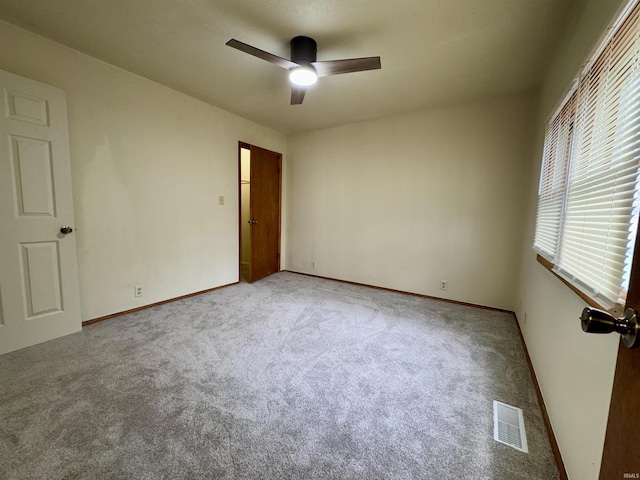 spare room featuring baseboards, ceiling fan, carpet flooring, and visible vents