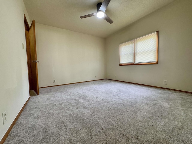 empty room with baseboards, carpet, a ceiling fan, and a textured ceiling