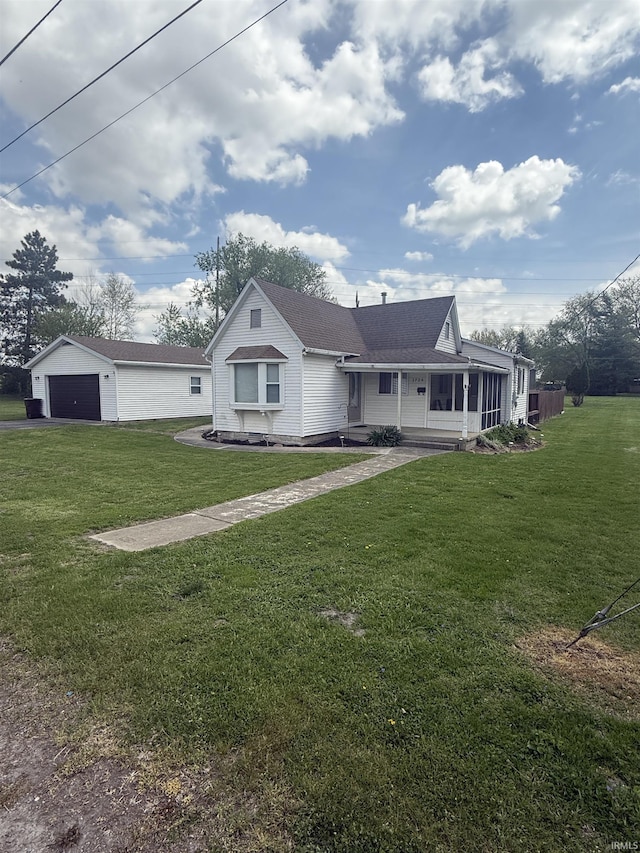 view of front of house featuring a detached garage and a front yard