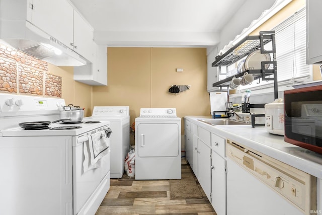 washroom with a sink, separate washer and dryer, laundry area, and light wood-style flooring