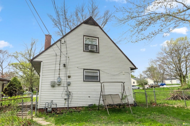 back of house with fence, a chimney, and a lawn