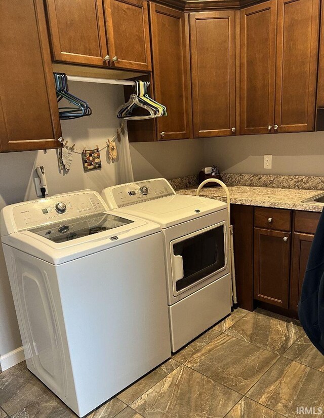 clothes washing area featuring cabinet space and washing machine and clothes dryer