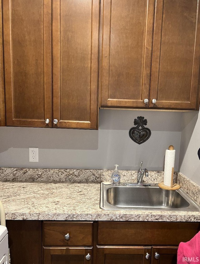 kitchen with a sink, light countertops, and dark brown cabinets