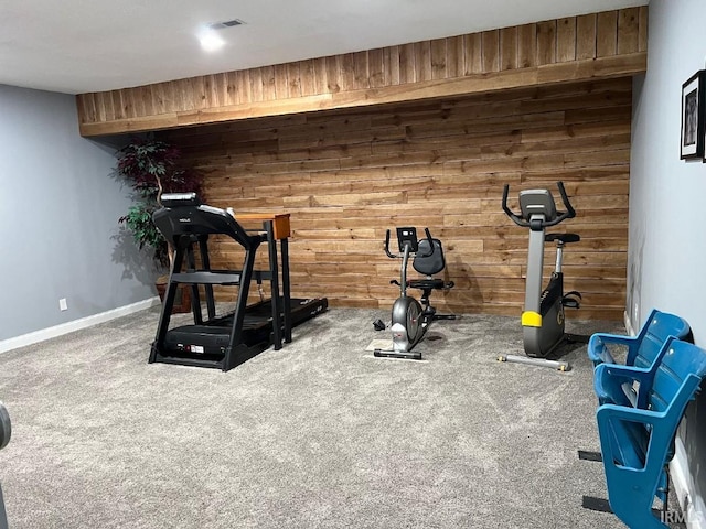 workout area featuring baseboards, carpet flooring, wood walls, and visible vents