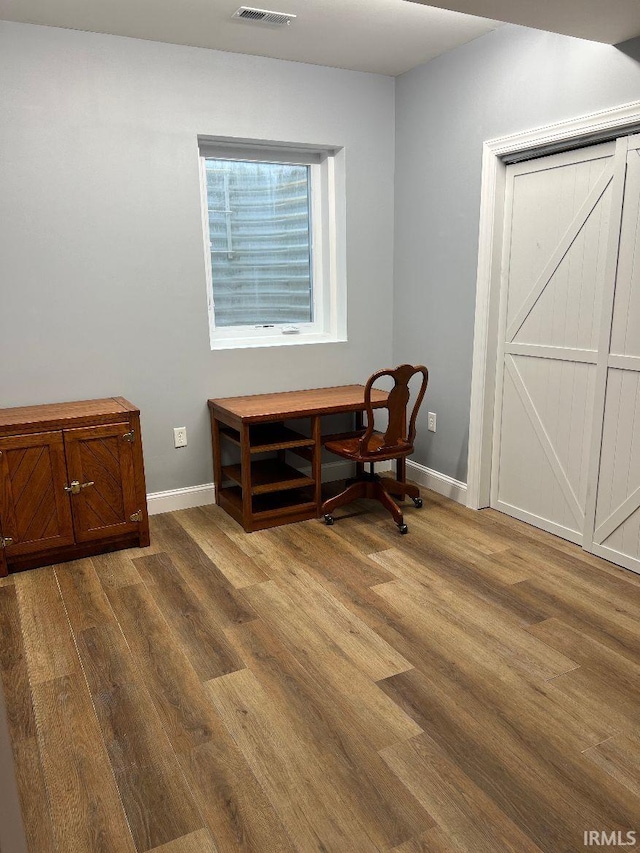 dining area with baseboards, wood finished floors, and visible vents