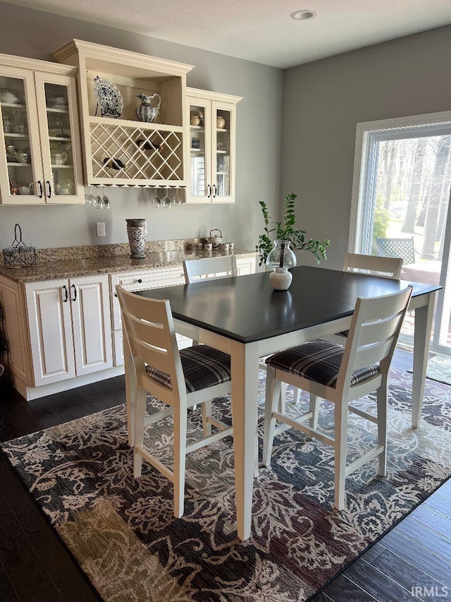 dining space with bar and dark wood finished floors