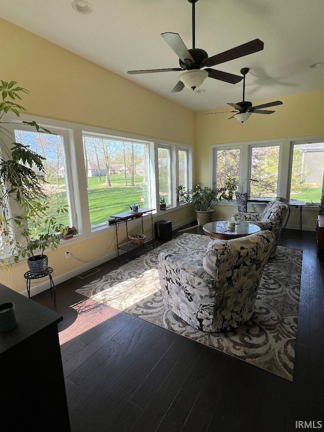 sunroom featuring baseboards, visible vents, and hardwood / wood-style floors