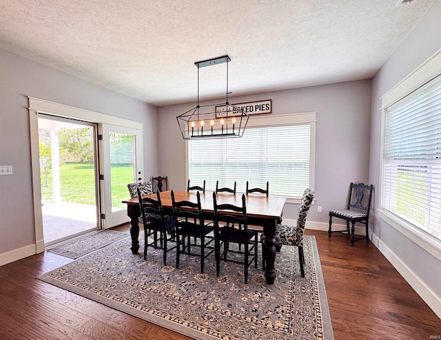 dining room with an inviting chandelier, baseboards, dark wood finished floors, and a textured ceiling