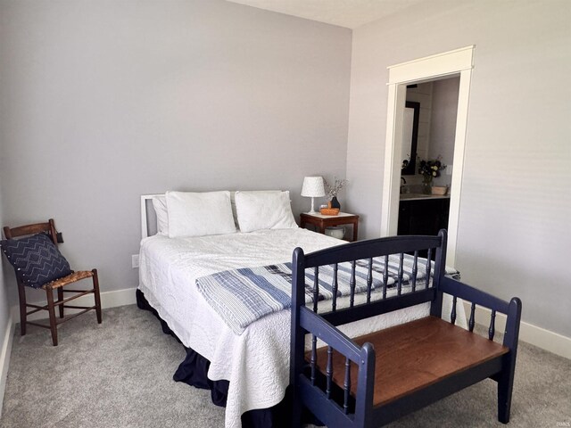 bedroom featuring baseboards, carpet, and ensuite bath