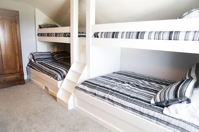 bedroom featuring vaulted ceiling and light carpet