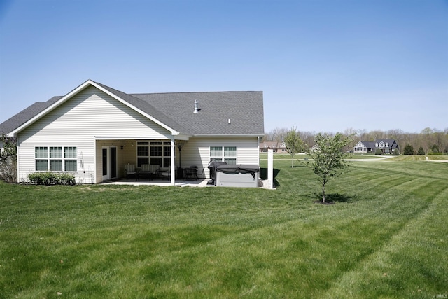 rear view of property featuring a hot tub, a patio, a yard, and outdoor lounge area