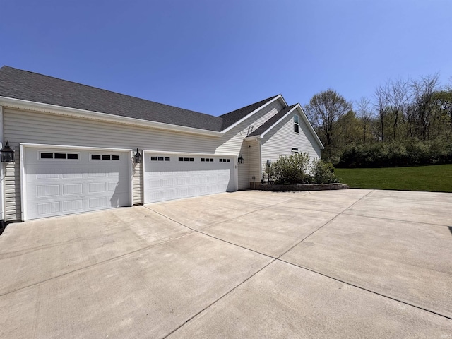view of side of property featuring an attached garage and driveway