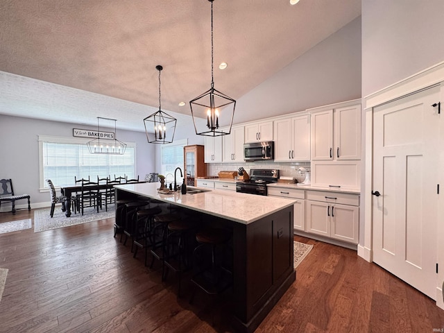 kitchen with range with electric stovetop, stainless steel microwave, and white cabinets