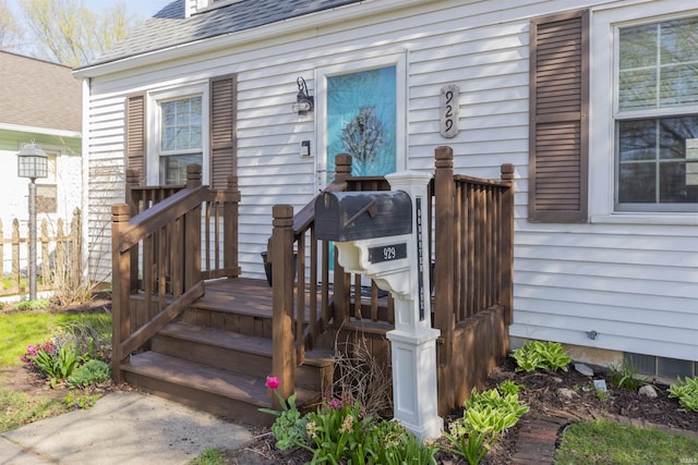 entrance to property featuring roof with shingles