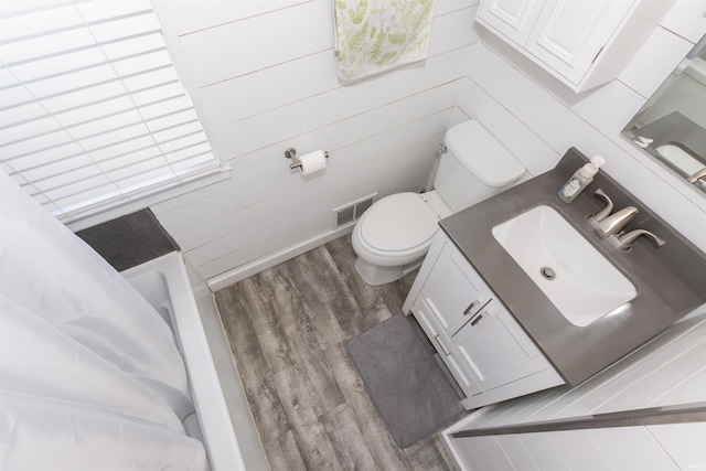 full bath with vanity, toilet, wood finished floors, and visible vents