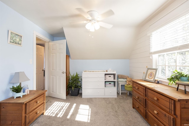 bedroom featuring multiple windows, vaulted ceiling, ceiling fan, and light colored carpet