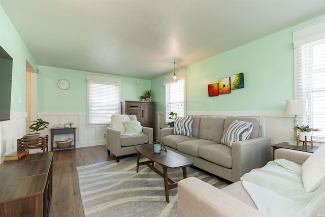 living room featuring plenty of natural light, wainscoting, and wood finished floors