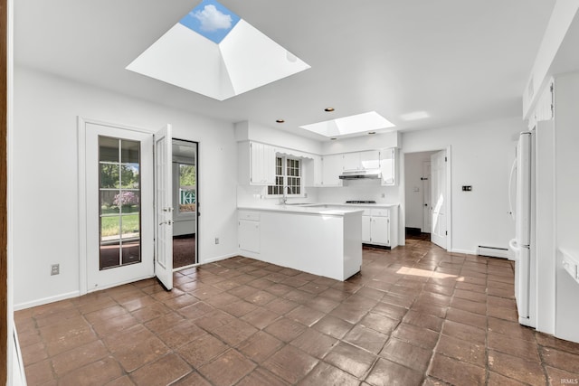 8818 Fortuna Way, Fort Wayne, IN 46815 - kitchen featuring a sink, a peninsula, a baseboard radiator, under cabinet range hood, and a skylight
