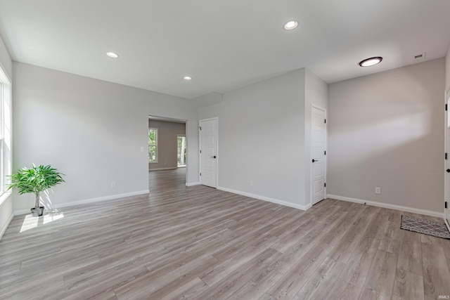 empty room with recessed lighting, baseboards, and light wood-type flooring