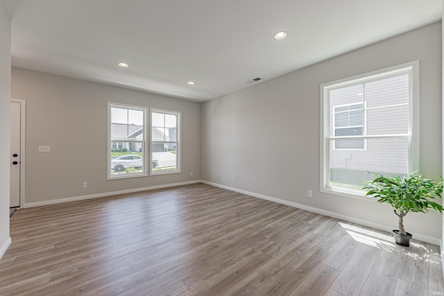unfurnished room with baseboards, recessed lighting, light wood-style flooring, and visible vents