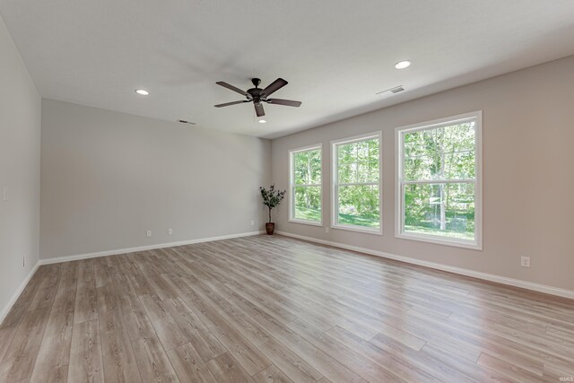 empty room with a ceiling fan, baseboards, and light wood-type flooring