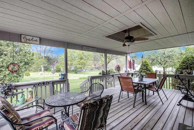 wooden terrace featuring a lawn, a ceiling fan, and outdoor dining area