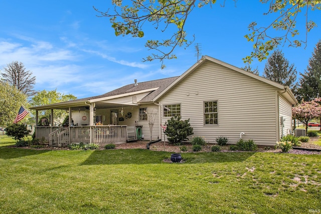 back of property with central AC unit and a yard