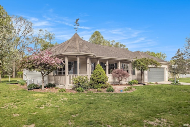 view of front of property with a shingled roof, a front lawn, a garage, covered porch, and driveway
