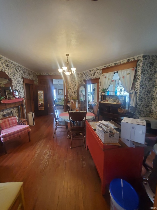 dining room with a notable chandelier, hardwood / wood-style floors, and wallpapered walls