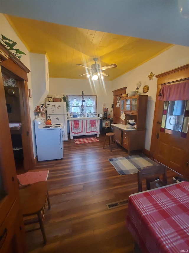 bedroom with freestanding refrigerator, visible vents, and dark wood-style floors