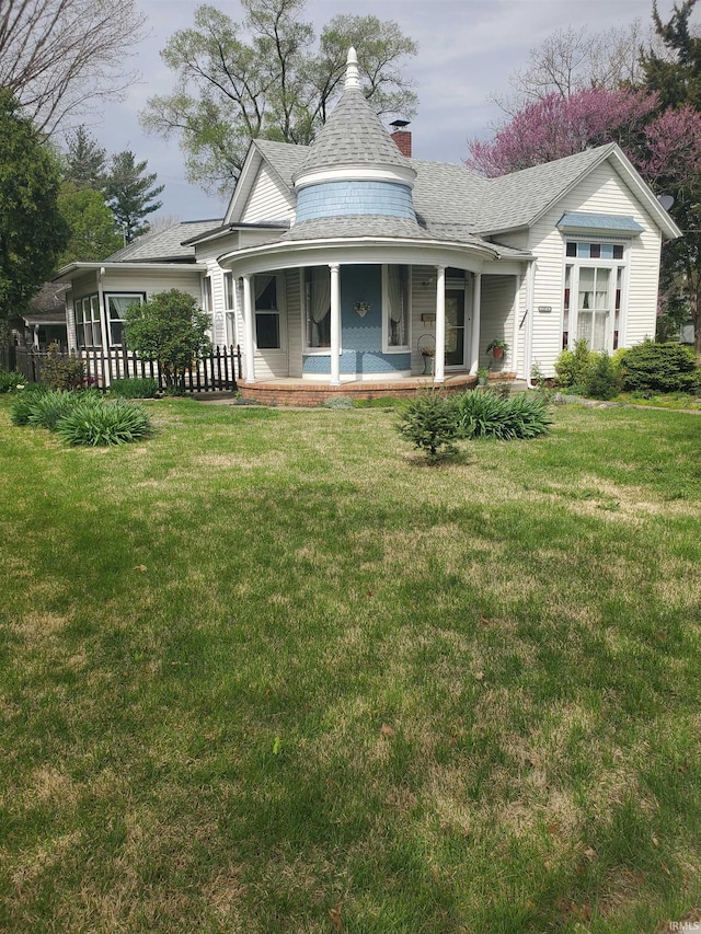 rear view of house with a yard, a chimney, and roof with shingles