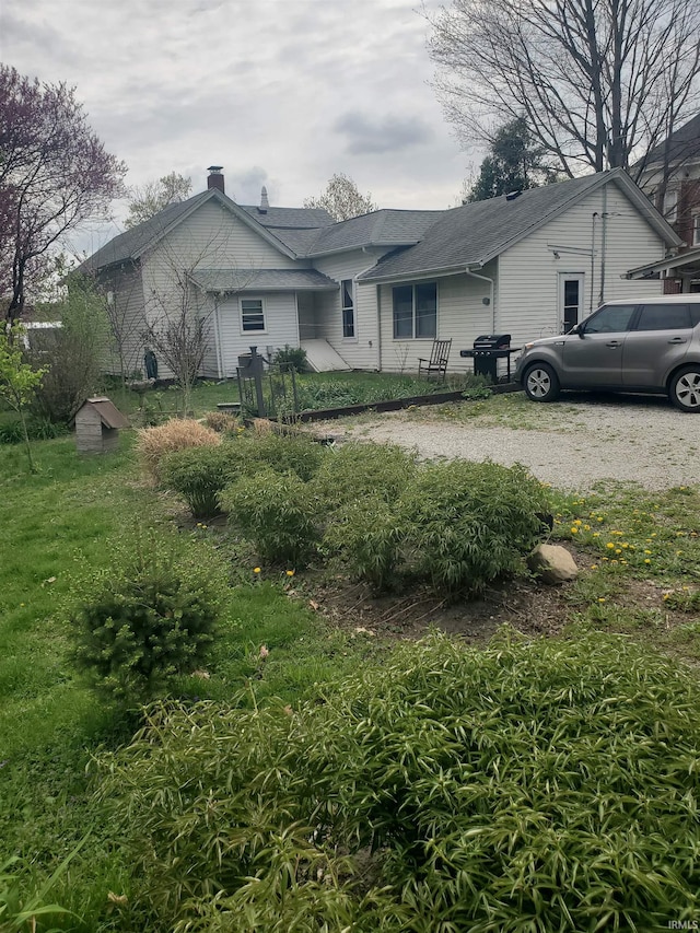 view of front of home featuring a shingled roof and a chimney