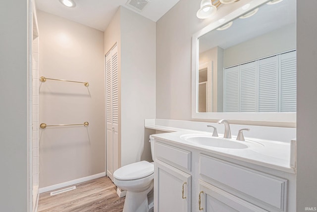 full bath featuring visible vents, a closet, vanity, wood finished floors, and toilet