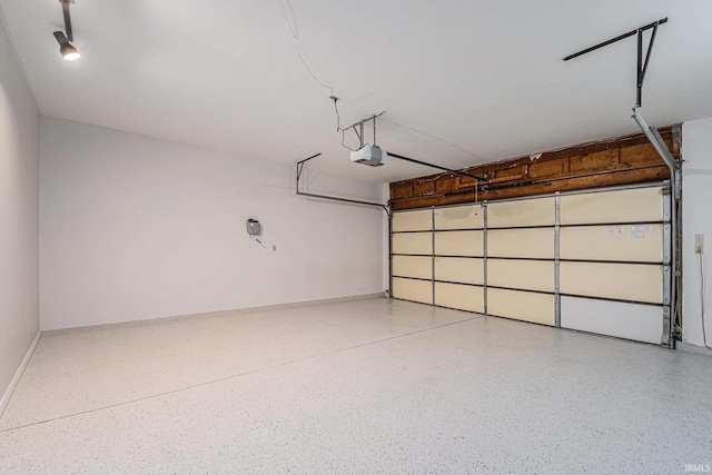 garage with baseboards and a garage door opener