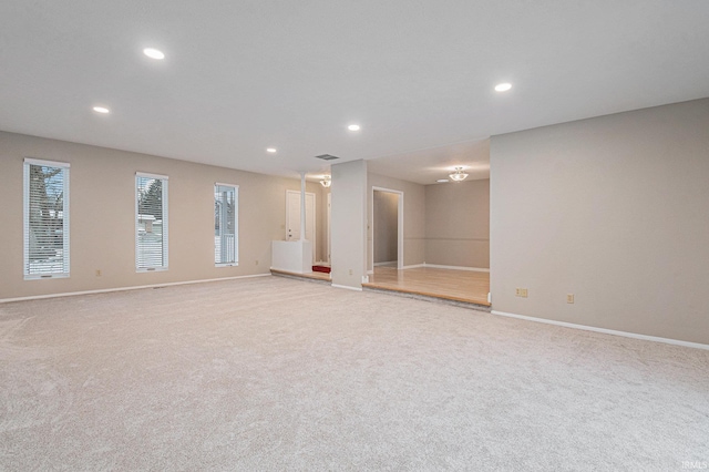 interior space featuring recessed lighting, baseboards, a wealth of natural light, and light carpet